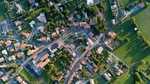Luftaufnahme eines Dorfes mit vielen kleinen Häusern mit Gärten und Straßen.