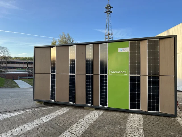 Eine zentraler Großbatteriespeicher von HanseWerk auch Wärmebox genannt, steht auf einem gepflasterten Untergrund.